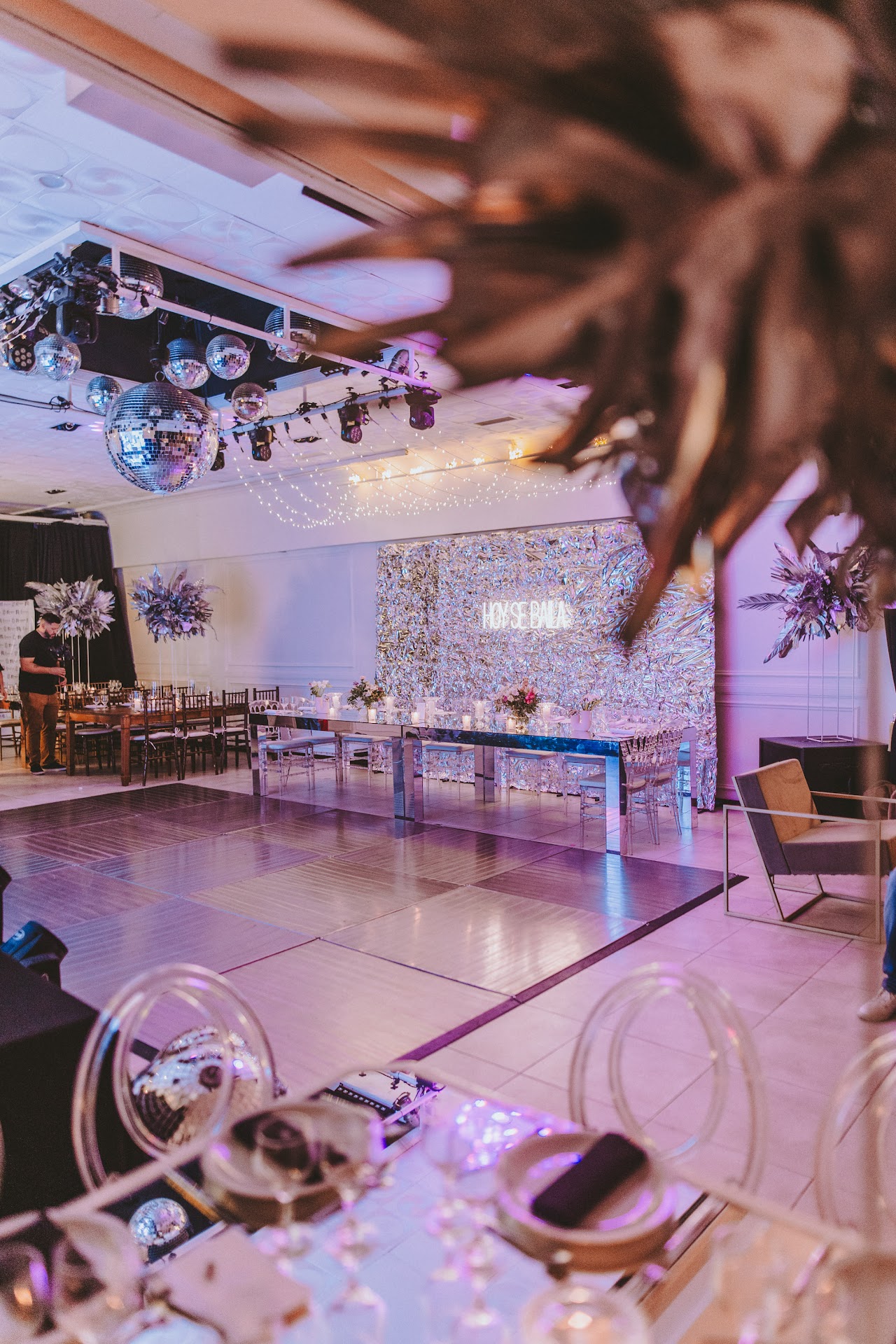 Pista de baile principal de Cezanne Eventos con bola de espejos gigante iluminada y cartel de neón HOY SE BAILA